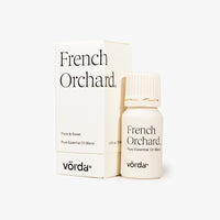 A small bottle of Vördä French Orchard pure essential oil blend next to its white packaging box, on a clean white background.