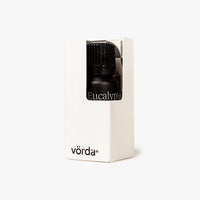 Vörda Eucalyptus essential oil in a white cardboard box with a clear window showing the dark bottle and cap, on a light gray background.