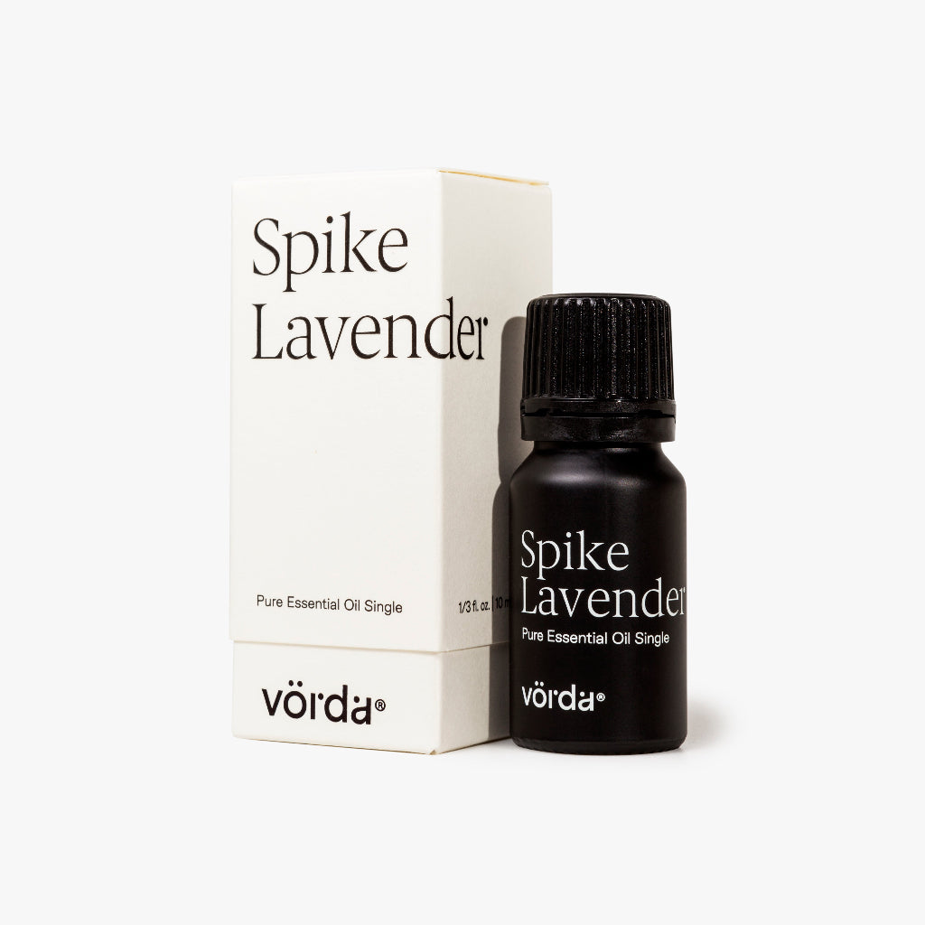 A bottle of Vörda Spike Lavender pure essential oil next to its white packaging box, set against a clean white background.