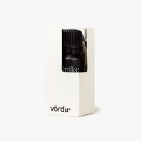 A small black bottle with a ribbed cap, partially visible inside a white rectangular box. The bottle has the word 'Spike' printed on it, and the box shows the brand name 'vörda' near the bottom.