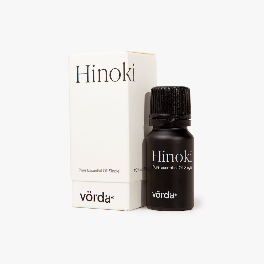 A bottle of Vörda Hinoki pure essential oil next to its white packaging box, set against a clean white background.