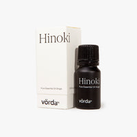 A bottle of Vörda Hinoki pure essential oil next to its white packaging box, set against a clean white background.