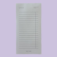 Notepad with lined pages on a light purple background