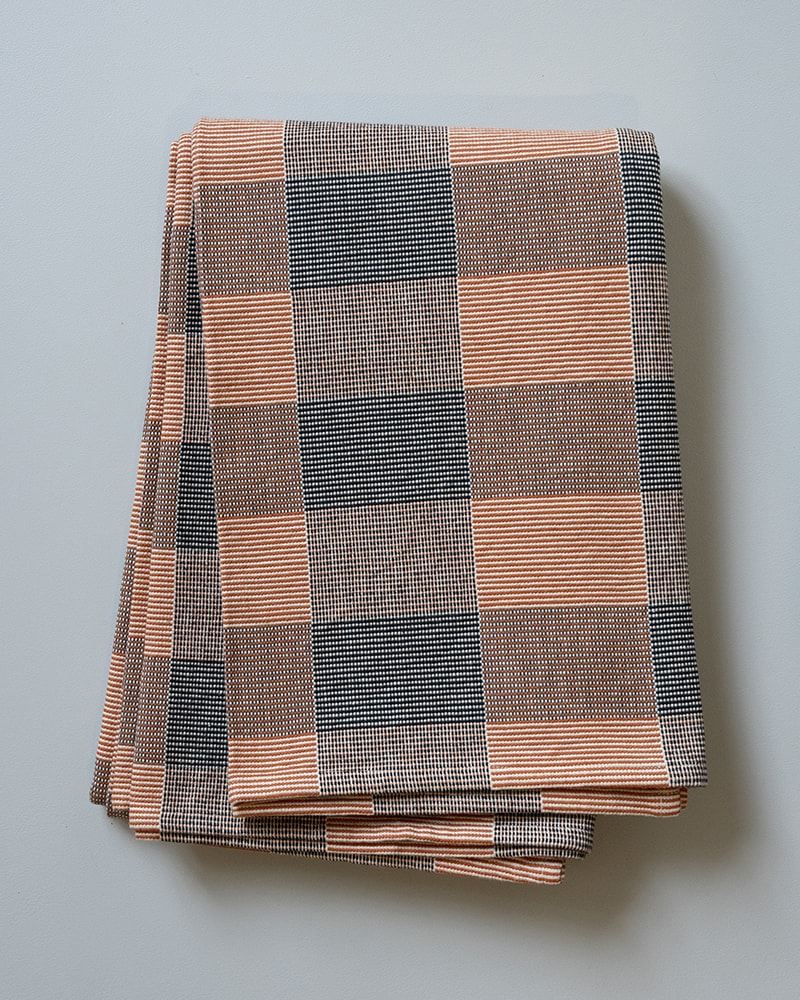 Folded plaid blanket with orange and blue pattern 