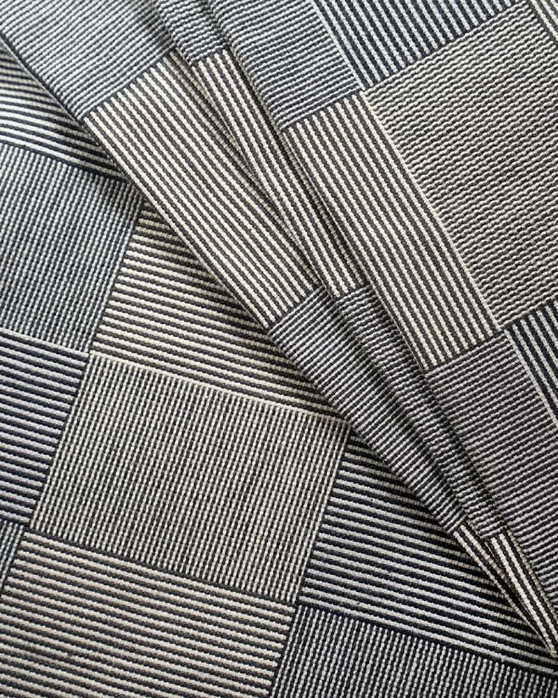 Close-up of a textured blanket with a striped, checkered pattern