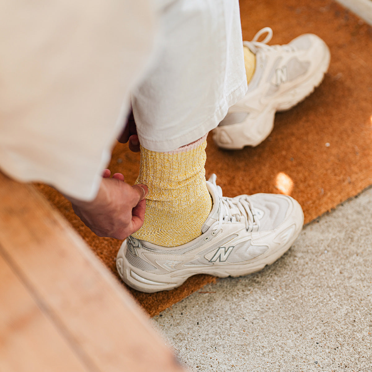 Person wearing yellow socks, white pants and sneakers