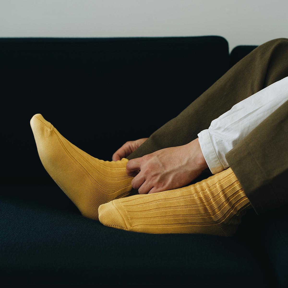 Feet of person wearing yellow socks on couch