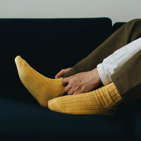 Feet of person wearing yellow socks on couch