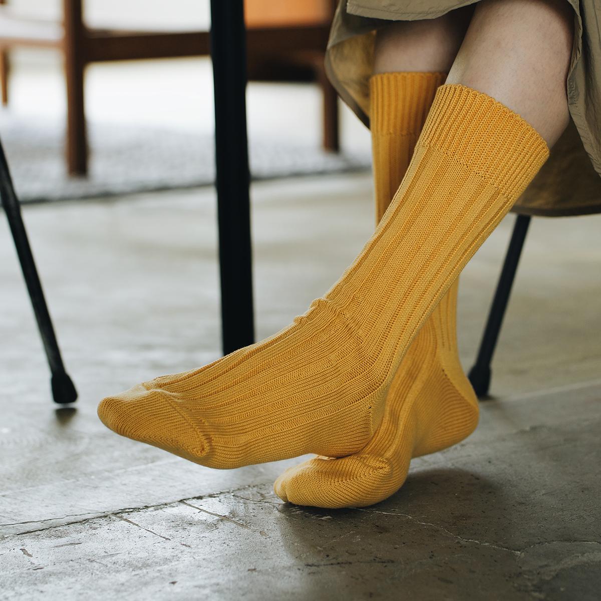 Feet of person sitting at a table wearing yellow socks