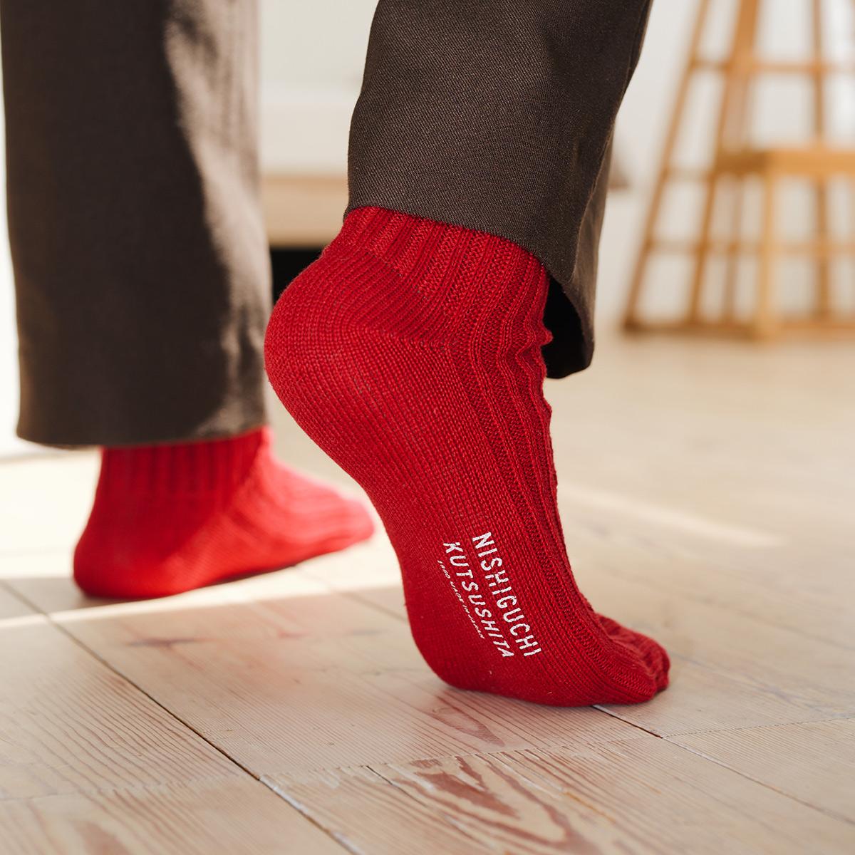 closeup of red socks on a person with brand logo visible