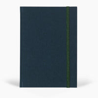 Dark blue notebook with a green strap on a white background