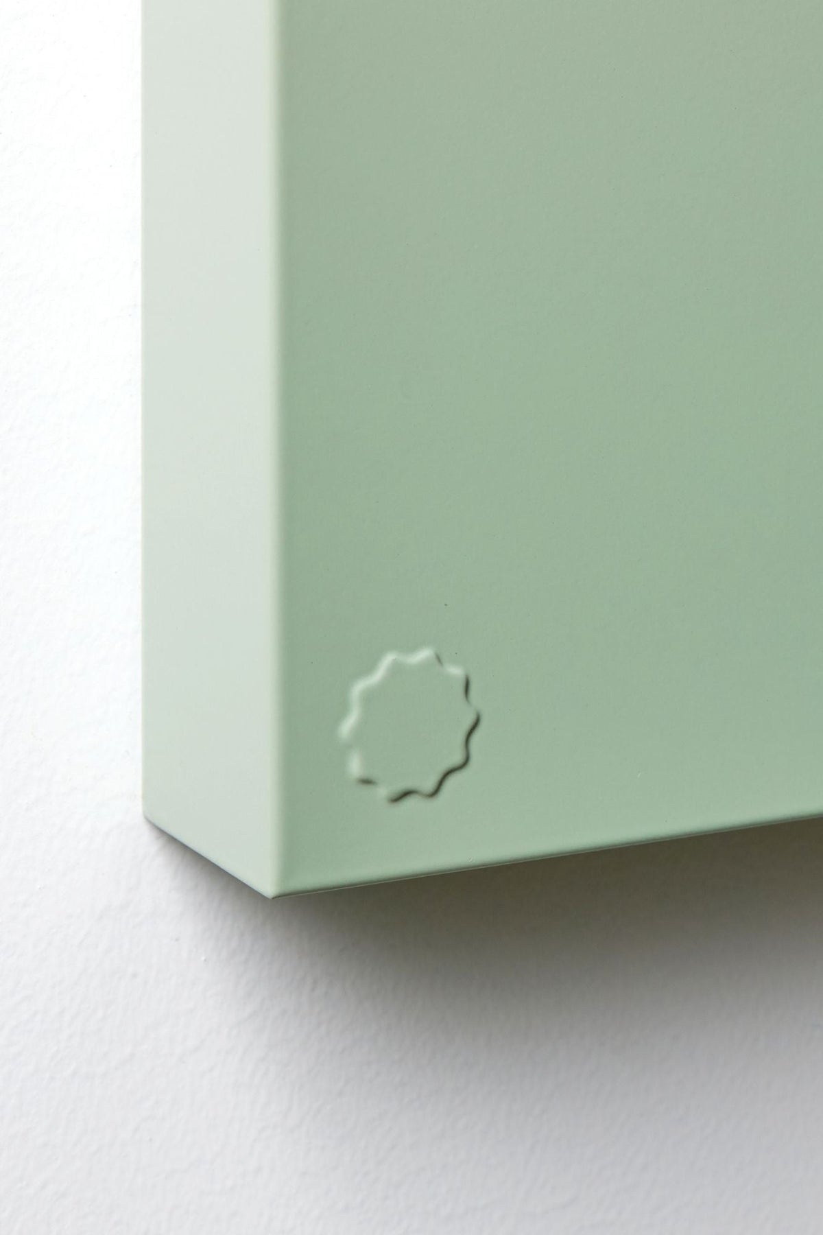 Close-up of a light green storyboard corner with a logo on a white background