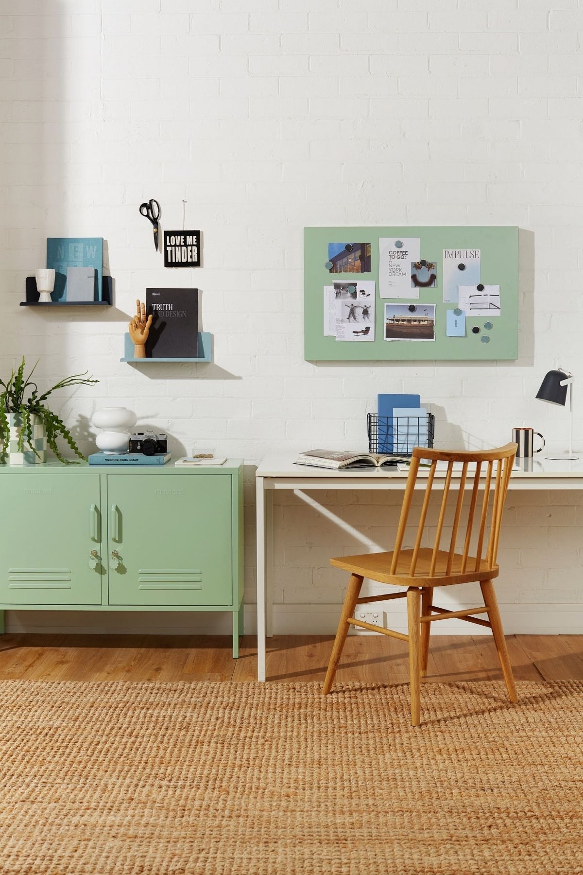 Home office with a green display board, green locker cabinet, desk, and chair.