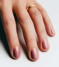 Hand with pink nail polish on a white background