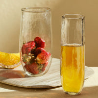 drinking glasses with liquid and fruit on a natural surface
