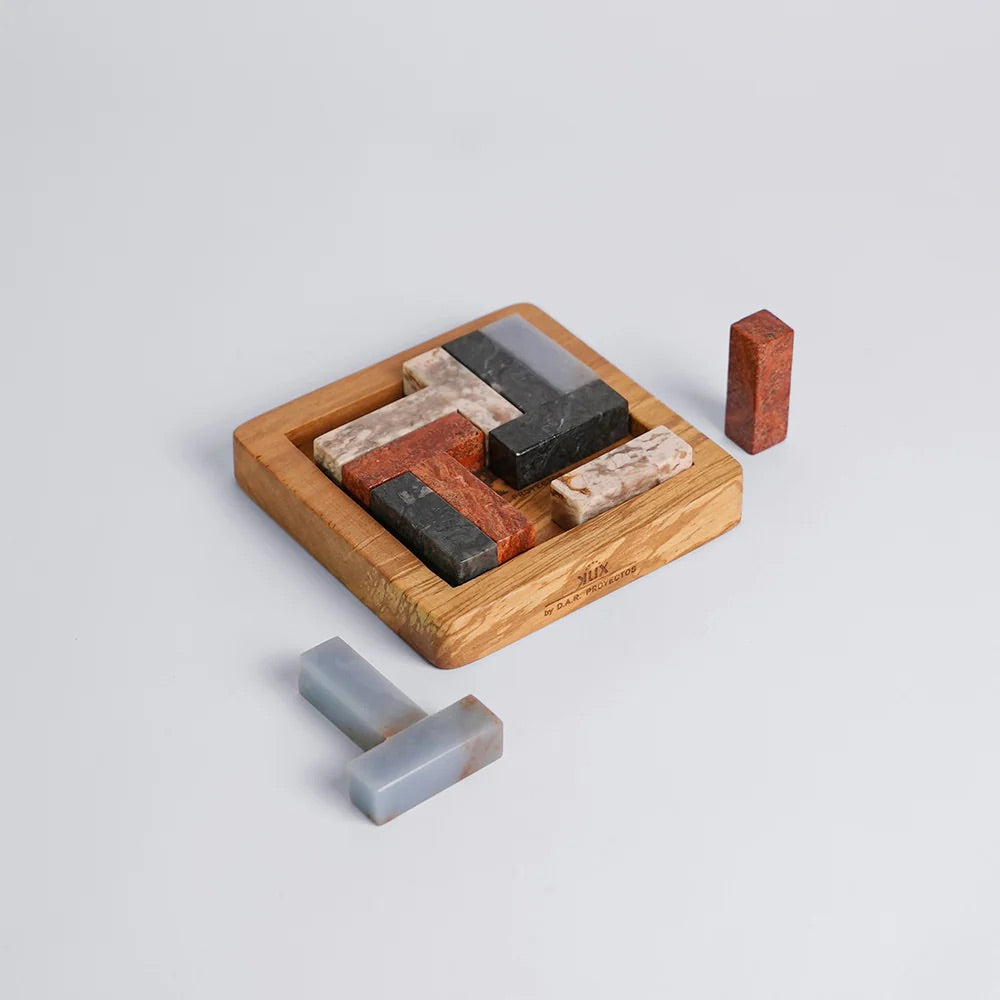 Set of stone puzzle pieces with a wood base on a light gray background