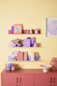 Shelves with decorative items against a yellow wall