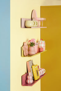 Shelves with decorative items against a multicolored wall