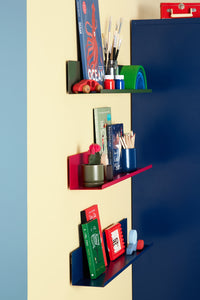 Colorful wall shelves with various items against a blue and yellow wall.