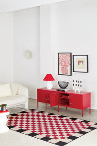 Modern living room with a red cabinet, white sofa, and geometric rug.