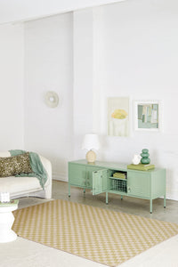 Modern living room with a green console table, white sofa, and decorative items.