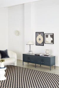 Modern living room with a dark gray console table, white sofa, and decorative items.