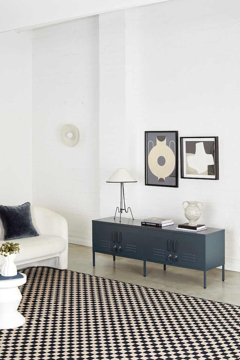 Modern living room with a dark gray console table, white sofa, and decorative items.
