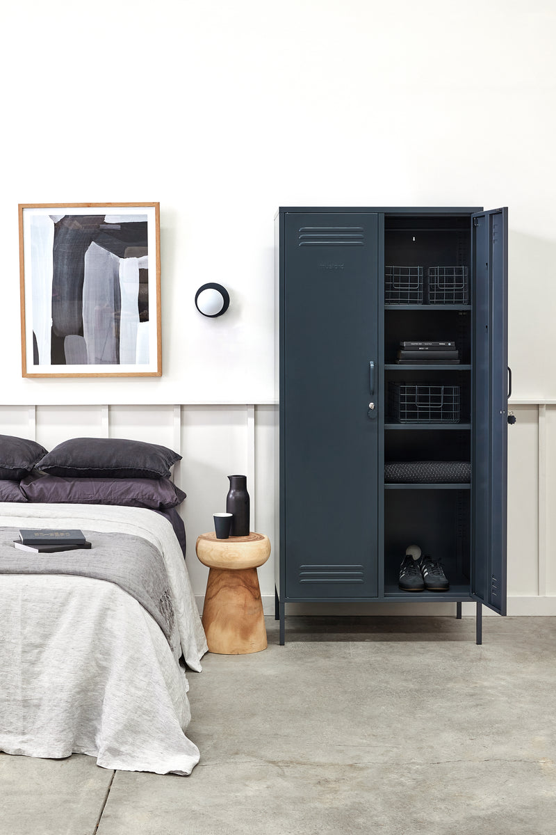 Modern bedroom with a dark gray locker, bed, and wall art.