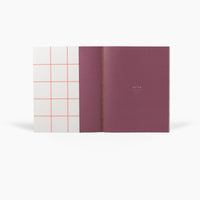 Two notebooks, one with a grid pattern cover and the other solid color, on a white background.