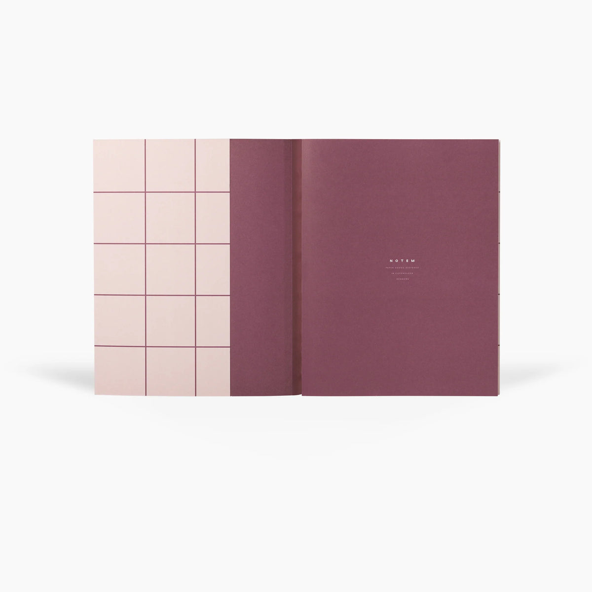 Pink and purple notebook with grid design on a white background