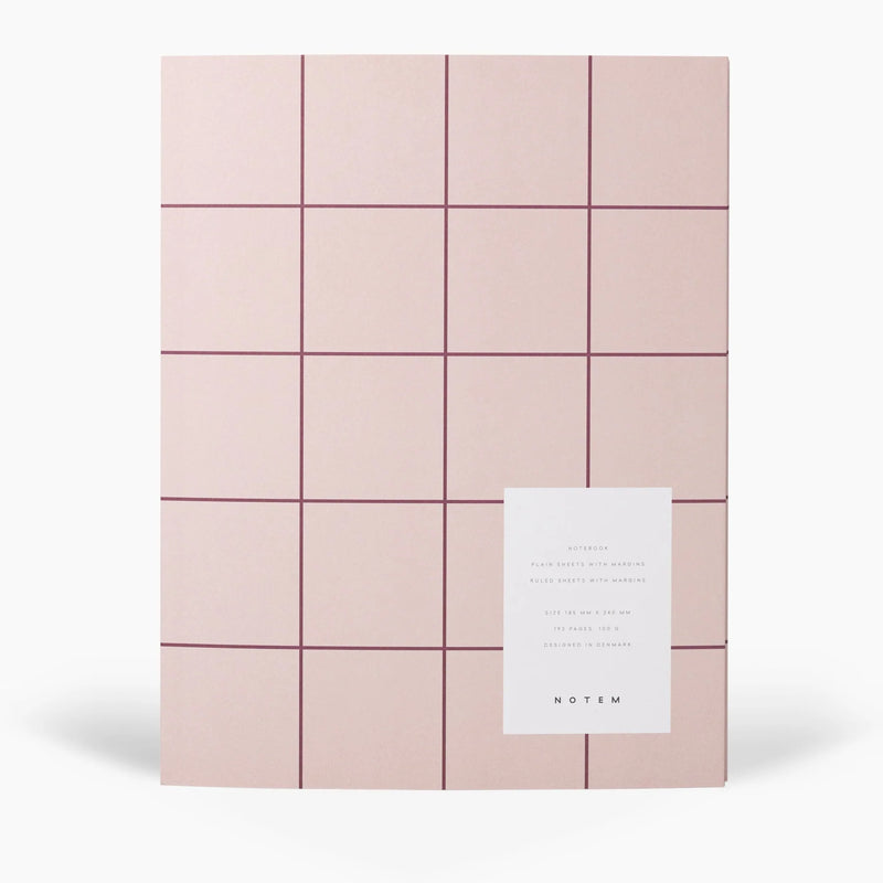 Pink grid-patterned journal with a white card on a white background