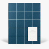 Blue grid-patterned notebook with a white label on a white background