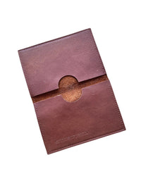 A brown leather passport holder with a circular cutout in the center, shown on a plain white background.