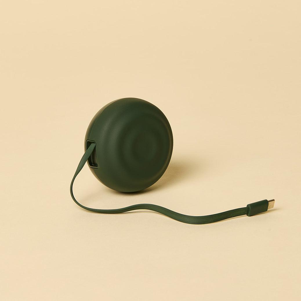 Green retractable charging cord on a beige background