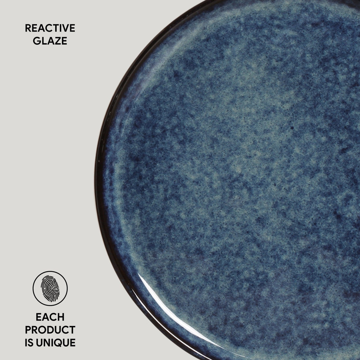 Close-up of a blue ceramic plate with reactive glaze on a light gray background