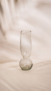 Clear glass vase on a textured beige surface