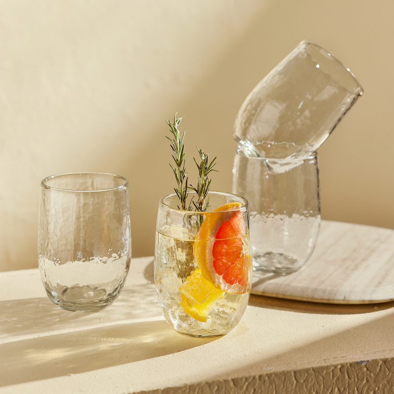 Set of four pebbled drinking glasses on a neutral surface