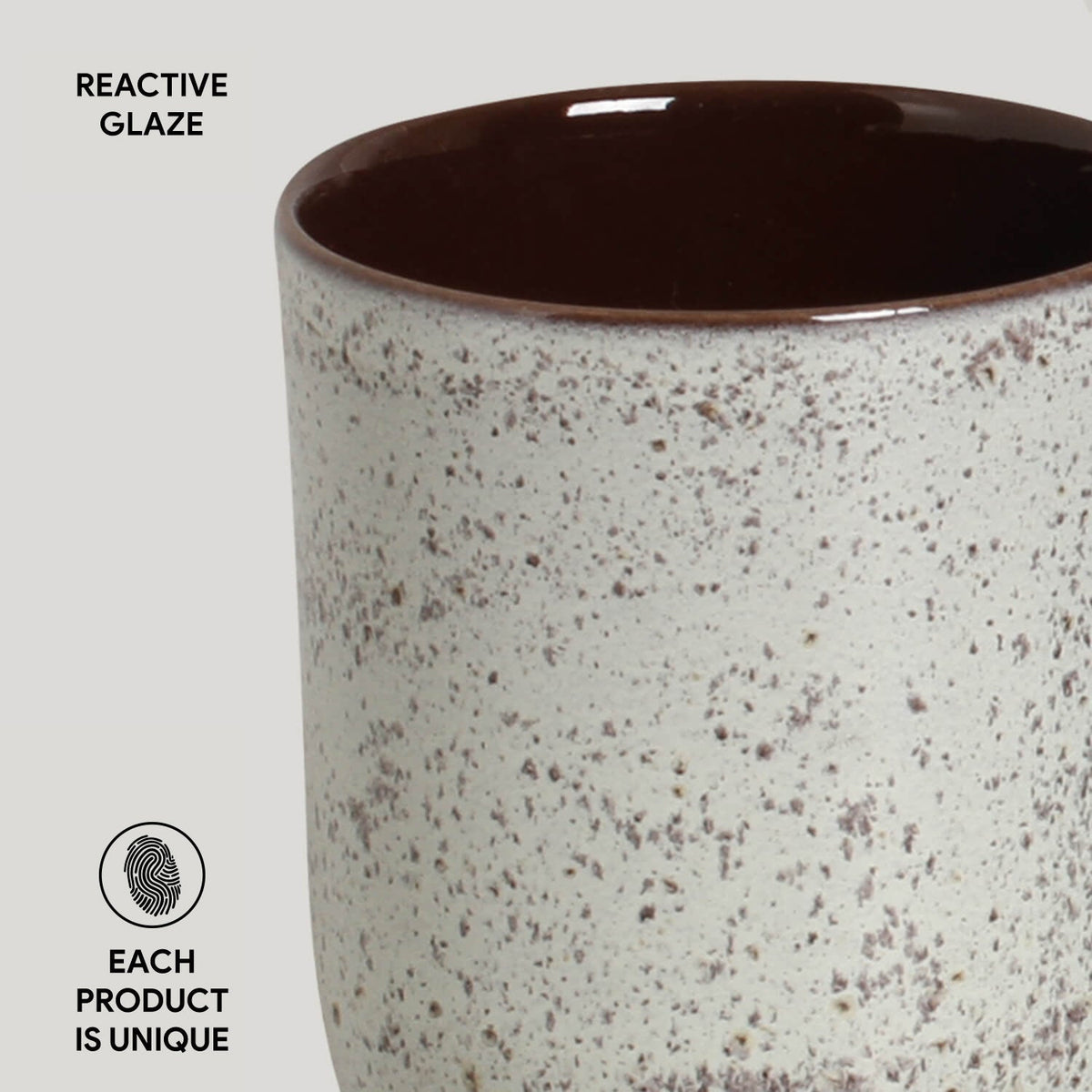 Ceramic cup with reactive glaze on a light gray background