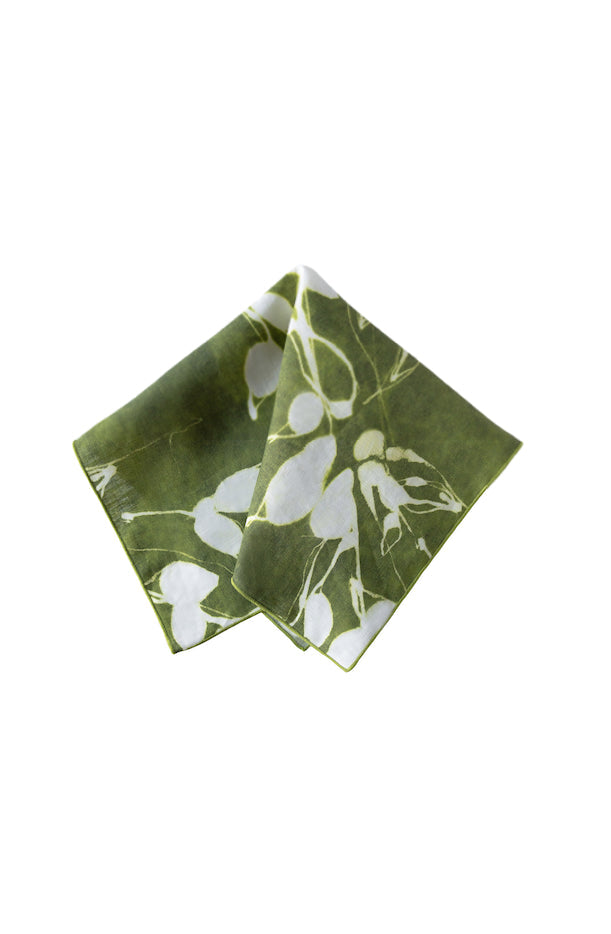 Green folded napkin with white floral pattern on a white background