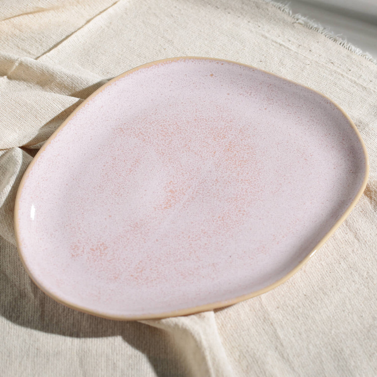 Pink ceramic plate on a textured beige surface