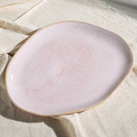Pink ceramic plate on a textured beige surface