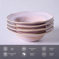 Stack of ceramic bowls with pink and beige glaze on a light gray background