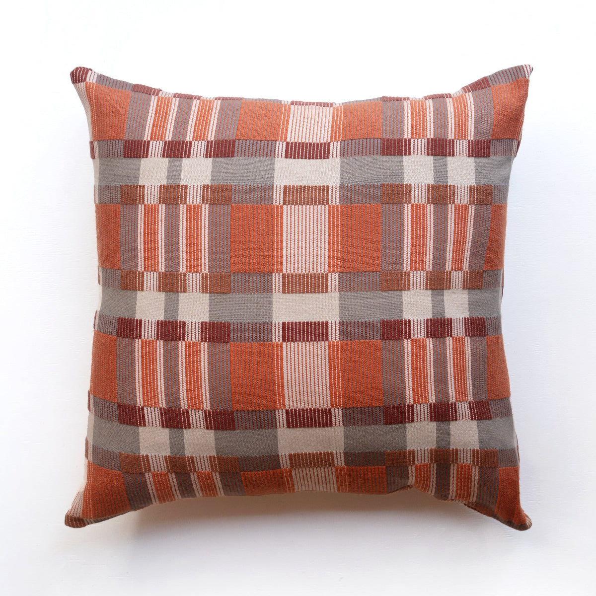 Checkered pillow with orange, brown, and beige pattern on a white background