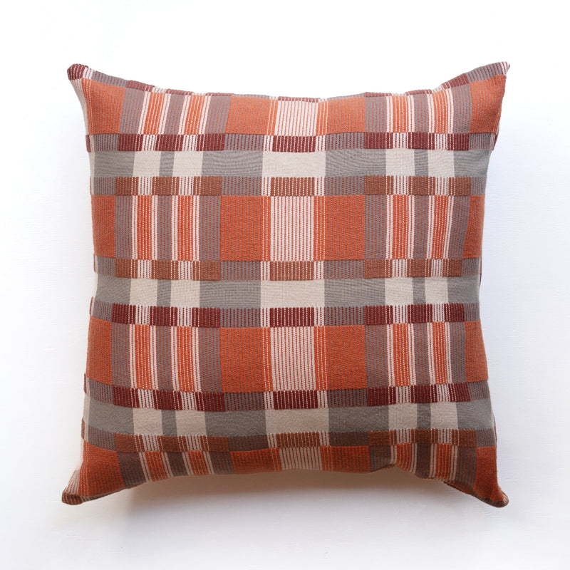 Checkered pillow with orange, brown, and beige pattern on a white background