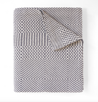 Folded blanket with geometric pattern on a white background