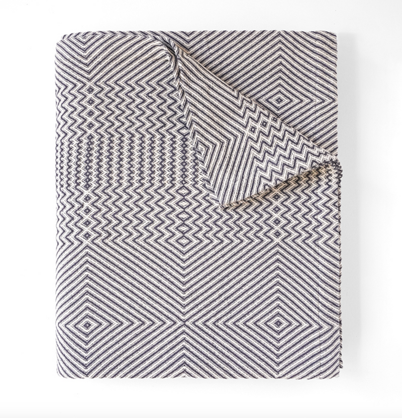 Folded blanket with geometric pattern on a white background