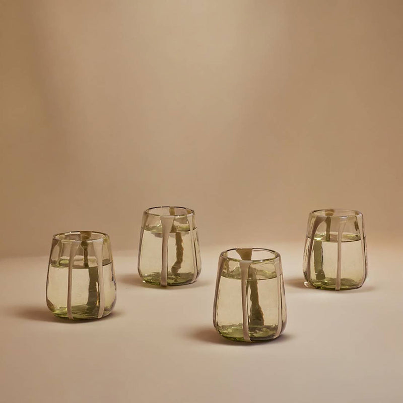 Four striped glass tumblers on a beige background