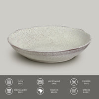 Speckled ceramic pasta plate on a gray background with safety and feature icons at the bottom.