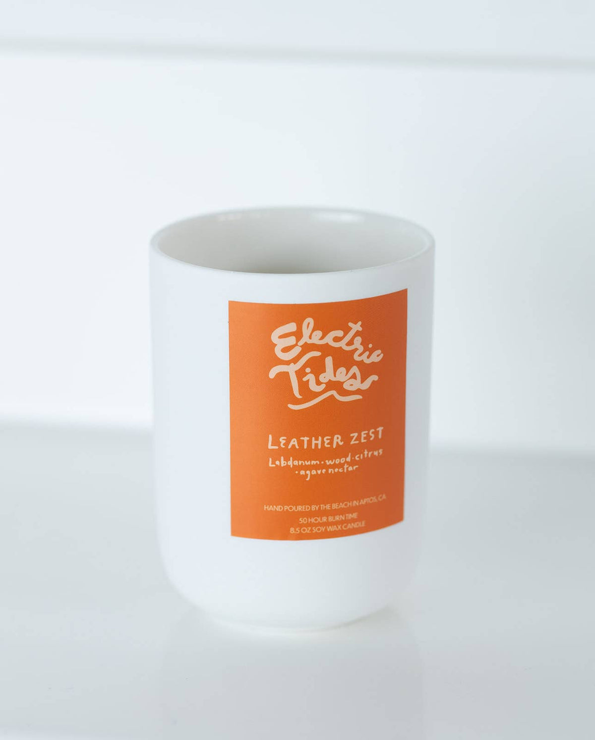 Candle with an orange label on a white background