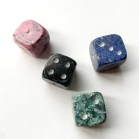 Four colorful stone dice on a white background